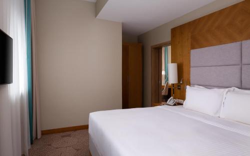 a large white bed in a hotel room at DoubleTree by Hilton Almaty in Almaty