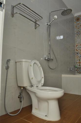 a bathroom with a toilet and a shower at The Swarna Hotel Bayah Lebak in Muaramadur