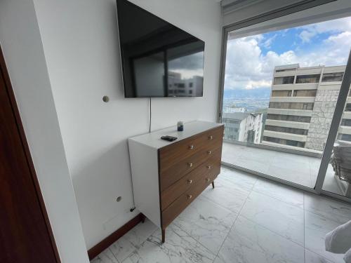 a bedroom with a dresser and a large window at Oh 801,Suit de lujo en Gonzalez Suarez in Quito