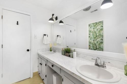 a white bathroom with two sinks and a mirror at Chic, modern retreat, kids&dog friendly, DT Matthews in Charlotte