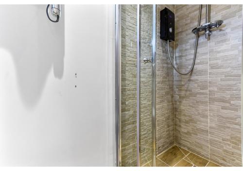 a shower in a bathroom with a glass shower backdoor at Charming Log Cabin with Hot Tub & Grill in London