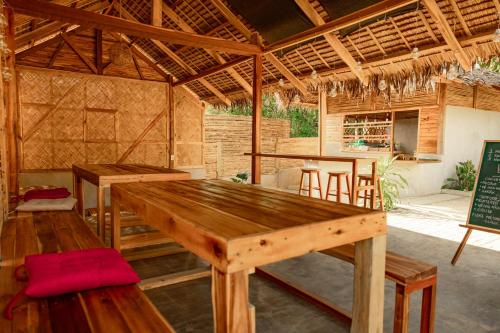 a large wooden table in a room with tables and chairs at Domes and Dreams Lio Glamping in El Nido