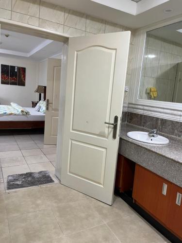 a bathroom with a white door and a sink at Mikocheni smart apartment in Dar es Salaam