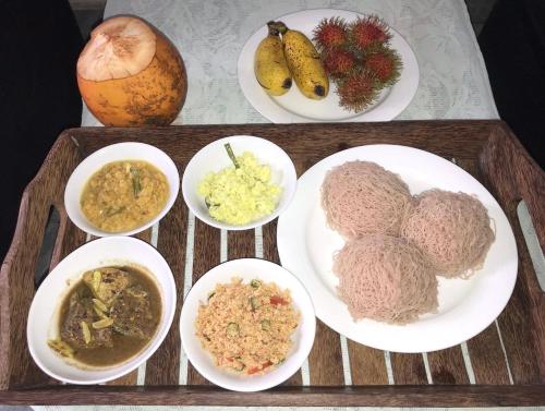 a tray with plates of food on a table at Luvi’s Villa in Galle
