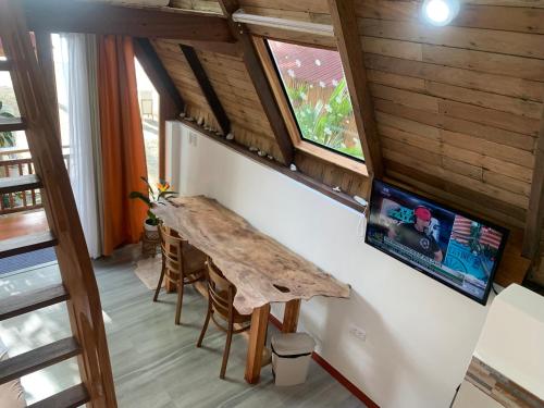 a room with a wooden table and a tv on a wall at A-House Beachfront 