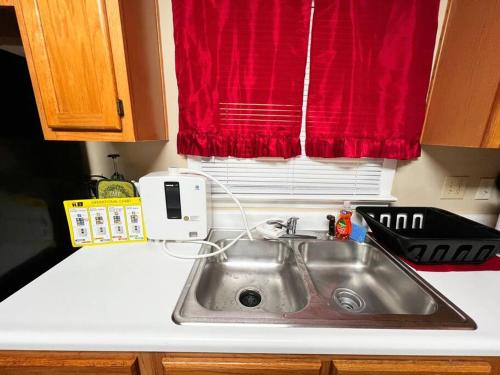 a kitchen counter with a sink and a red window at Foundation Paradise in Fayetteville