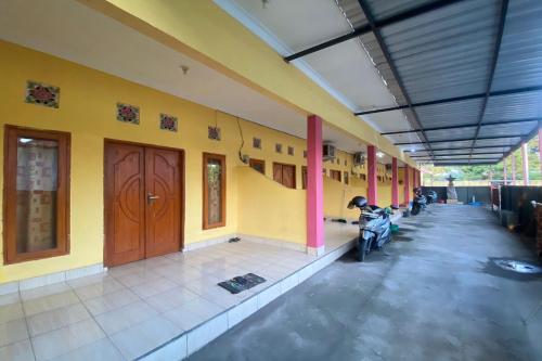 a building with a motorcycle parked inside of it at OYO Life 93259 Kos Kurnia in Tanjung