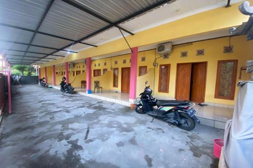 a group of motorcycles parked in a building at OYO Life 93259 Kos Kurnia in Tanjung