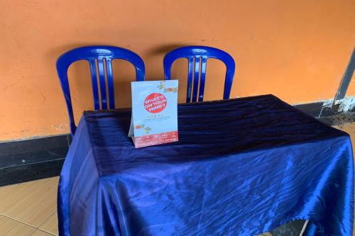 a blue table with two blue chairs with a box on it at OYO Life 93259 Kos Kurnia in Tanjung
