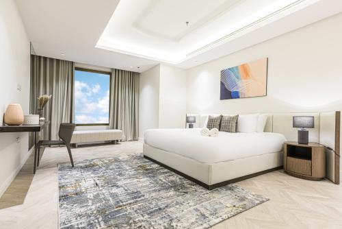 a white bedroom with a bed and a couch at Stella Stays Olaya Tower 1 in Riyadh