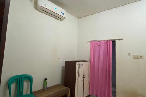 a room with a pink curtain and a refrigerator at OYO Life 93259 Kos Kurnia in Tanjung