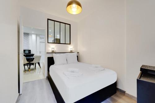 Schlafzimmer mit einem weißen Bett und einem Schreibtisch in der Unterkunft Comfortable apartment Marx Dormoy in Paris