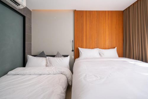 two beds sitting next to each other in a room at Woodstory Boutique Hotel in Bangkok