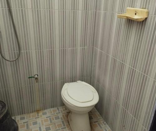 La petite salle de bains est pourvue d'une douche et de toilettes. dans l'établissement OYO Life 93265 Kos Cendana Seruni Raya, à Mataram