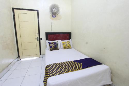 丹戎的住宿－OYO Life 93260 Bale Kosan，一间卧室配有黄色和蓝色枕头的床