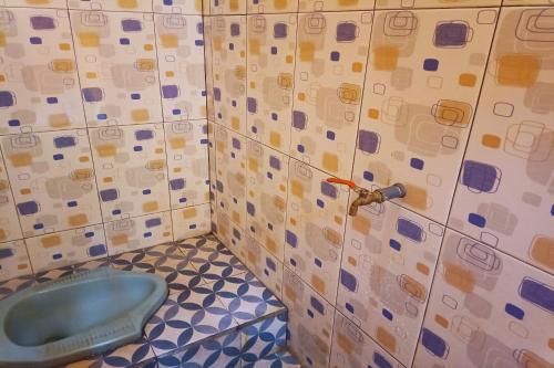 丹戎的住宿－OYO Life 93260 Bale Kosan，一间铺有瓷砖的客房内浴室,内配蓝色的卫生间