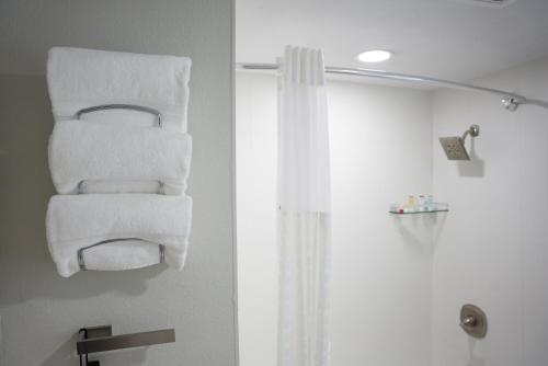 a stack of towels on a towel rack in a bathroom at Ramada by Wyndham DFW Airport in Irving