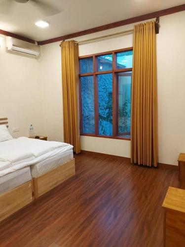 a bedroom with a bed and a large window at Oi Beach in Maamigili