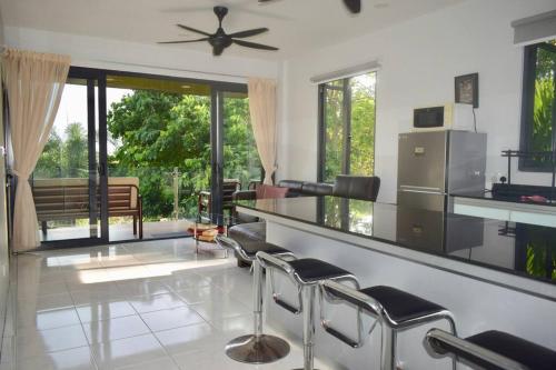 ein Wohnzimmer mit Stühlen und einem Deckenventilator in der Unterkunft 2 bedrooms Apartment in Pantai Cenang
