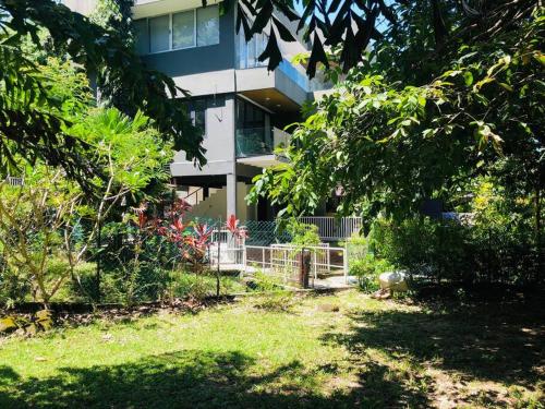 ein Gebäude mit einem Zaun vor einem Hof in der Unterkunft 2 bedrooms Apartment in Pantai Cenang