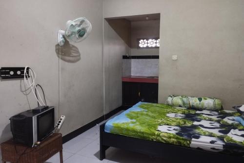 1 dormitorio con 1 cama, ventilador y TV en OYO Life 93403 Penginapan Adinda, en Tjakranegara
