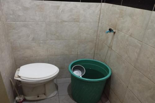 bagno con servizi igienici e cestino verde di OYO Life 93403 Penginapan Adinda a Tjakranegara
