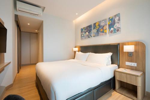 a bedroom with a white bed and a tv at Zenity 3BR Condo: Luxury and Comfort in Quận 1 in Ho Chi Minh City