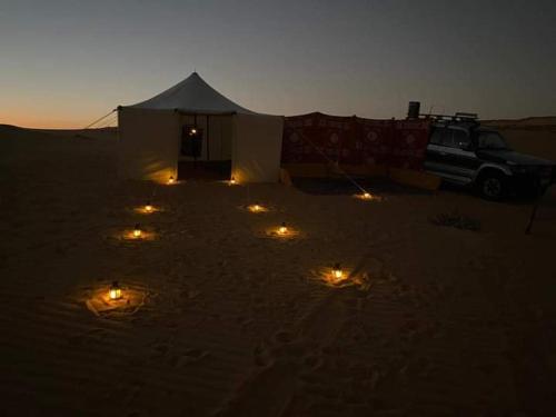 a tent with lights in the desert at night at Nuba falcon in Aswan