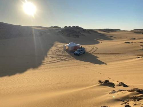 Nuba falcon في أسوان: شاحنة في صحراء مع الشمس في الخلف