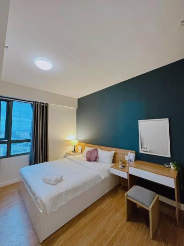 een slaapkamer met een groot bed, een bureau en een muur bij Luxury apartment in Masteri Thao Dien Free Gym, Pool in Ho Chi Minh-stad