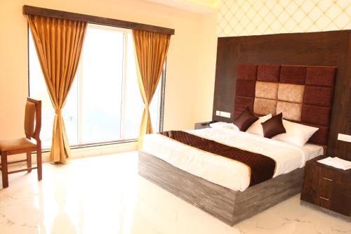 ein Schlafzimmer mit einem großen Bett und einem großen Fenster in der Unterkunft SAS SQUARE in Tiruchchirāppalli
