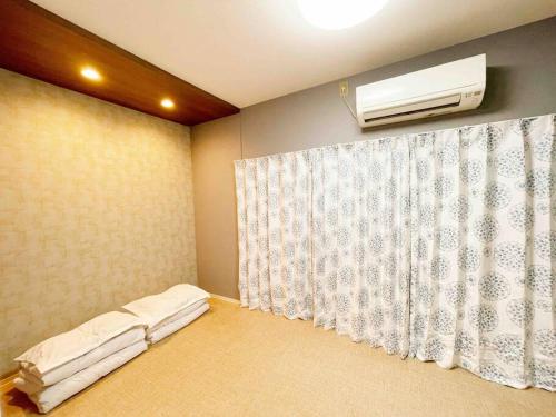 una camera con un letto dotato di condizionatore d'aria e tenda di 華·【橘和梦】/栄まで地下鉄4分/千種駅徒歩5分 a Nagoya