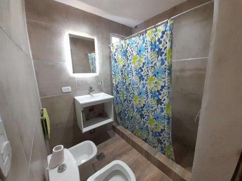a bathroom with a toilet and a shower curtain at Casa Blend in Las Heras
