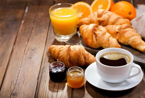 a table with a cup of coffee and orange juice at Magnificent Hotel in Kathmandu