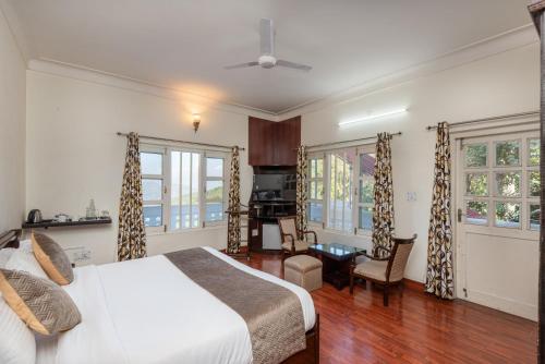 1 dormitorio con 1 cama y sala de estar en Tehri Club Resort By DLS Hotels, en Chamba