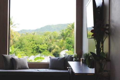 a couch sitting in front of a large window at The Willow Phangan in Koh Phangan