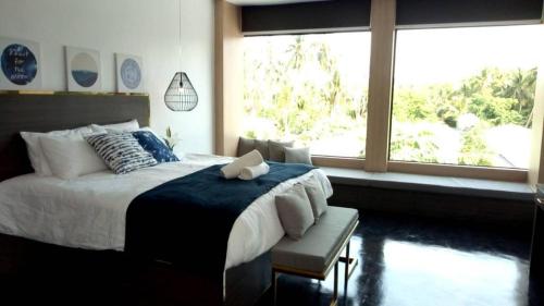 a bedroom with a large bed and a window at The Willow Phangan in Koh Phangan