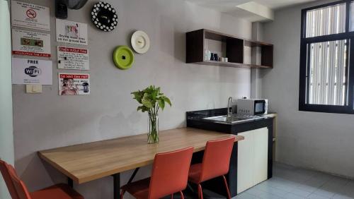 a kitchen with a table with chairs and a vase on it at Terminal58hostel@town in Ban Lo Long