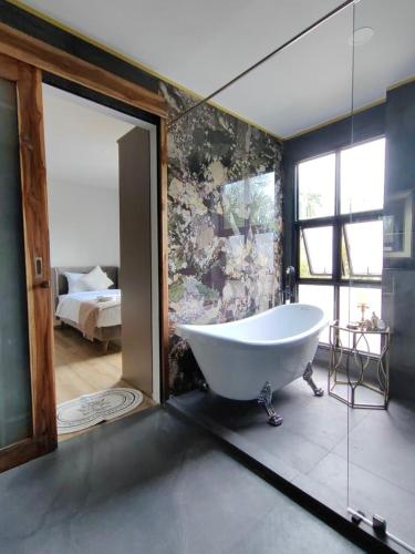 a large bathroom with a tub and a bedroom at The Willow Phangan in Koh Phangan