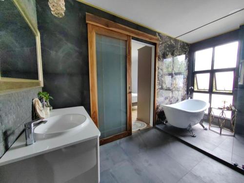 a bathroom with a tub and a sink and a bath tub at The Willow Phangan in Koh Phangan