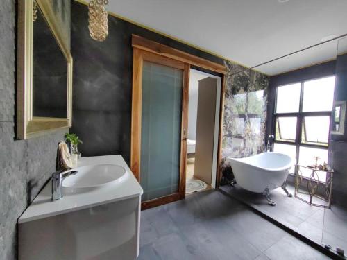 a bathroom with a tub and a sink and a bath tub at The Willow Phangan in Koh Phangan