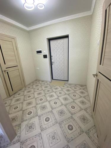 een kamer met een deur en een tegelvloer bij Уютная однушка в новостройке in Karagandy
