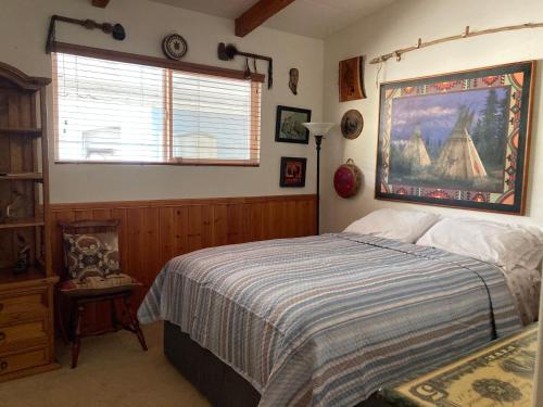 a bedroom with a bed and a painting on the wall at Kernville - walk to River Kern & Downtown in Kernville
