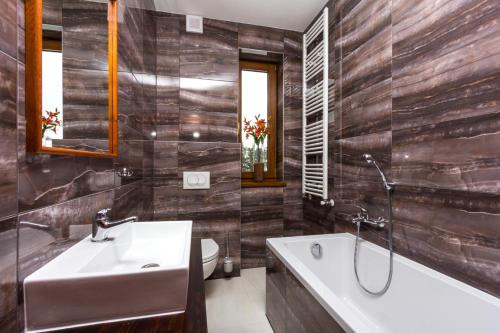a bathroom with a tub and a sink and a bath tub at Boutique Hotel Budzak in Ždiar
