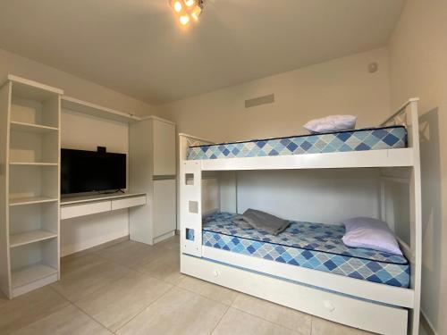 a bedroom with two bunk beds and a flat screen tv at Sunset Village in Villa Carlos Paz