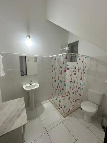 a bathroom with a shower and a toilet and a sink at Casa de Maria Marta in Ilhéus