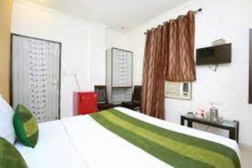 1 dormitorio con 1 cama en verde y blanco en HOTEL AXIS INN, Amritsar, en Amritsar