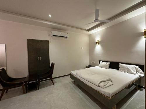 a bedroom with a bed and a desk in it at Hotel Surbhi in Mundra