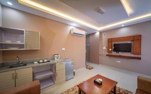 a large kitchen with a sink and a table at RED-5 - AL Safa Suites in Salalah