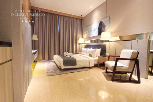 a hotel room with a bed and a chair at Menteng Park Exclusive Emerald in Jakarta